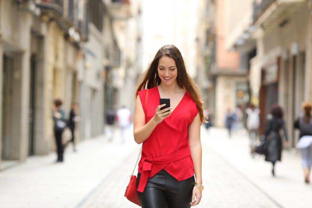 Girl looking at a cell phone on the street