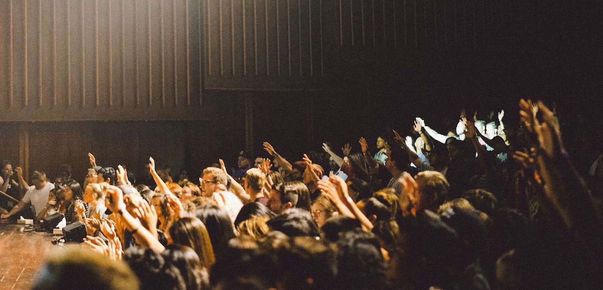 Público alzando la mano